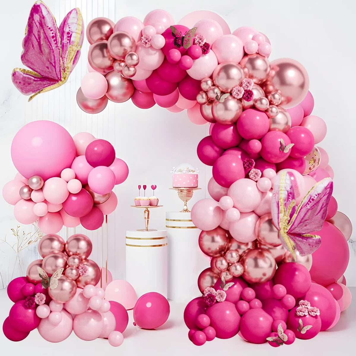 A large arch of pink and magenta latex balloons decorated with floral accents and butterfly shapes.