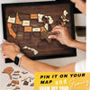 Hands are placing stickers onto a wooden USA travel map puzzle for a journey.