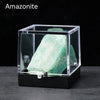 A clear box displays a large, translucent green amazonite crystal specimen.