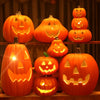 A collection of glowing orange Halloween pumpkins displayed on a wooden shelf.