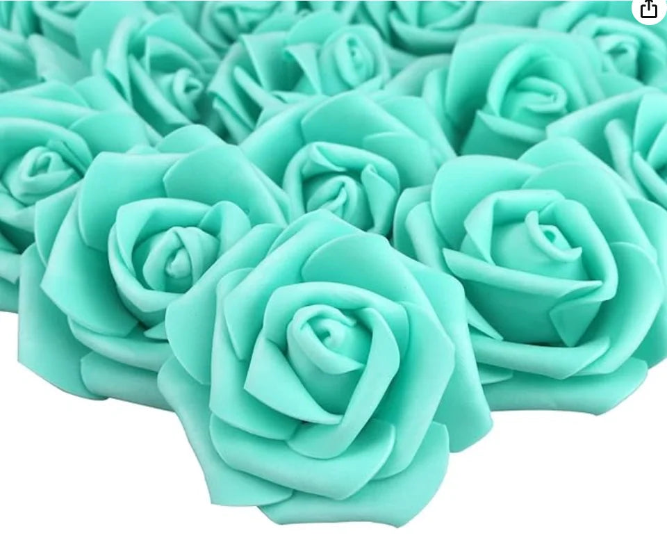 A close-up view of artificial foam rose decorations in a mint green color.