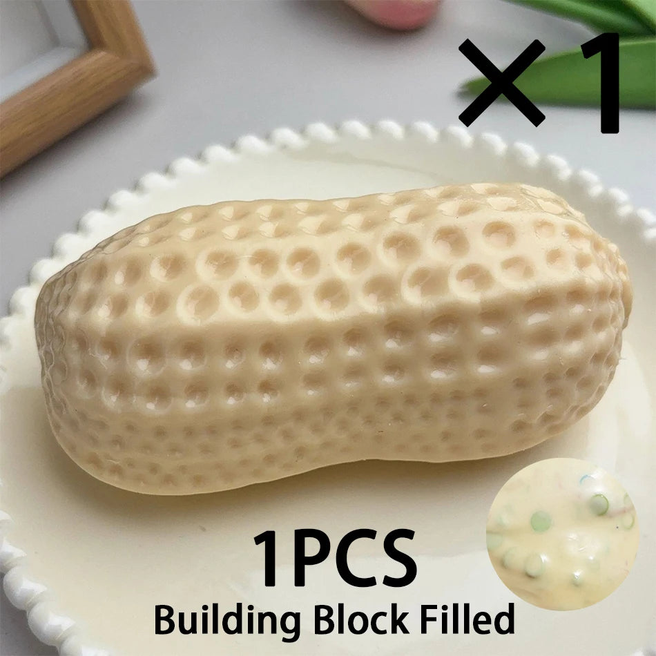 A beige peanut-shaped building block filled with small spheres, shown on a white plate.