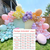 A colorful balloon garland kit featuring pink, blue, yellow, purple, and blush balloons arranged on a green lawn.