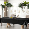 Elegant black disposable plastic tablecloth set for weddings and parties displayed on a table.