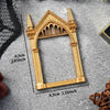 A vintage gold DIY shadow box frame with an arched gothic design displayed on a gray surface.