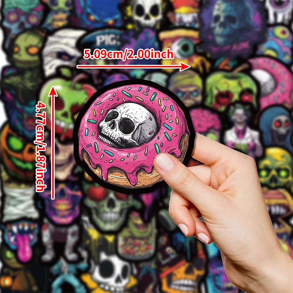 A hand holds a pink frosted skull decal sticker, showing its size next to a colorful background of skulls and monsters.