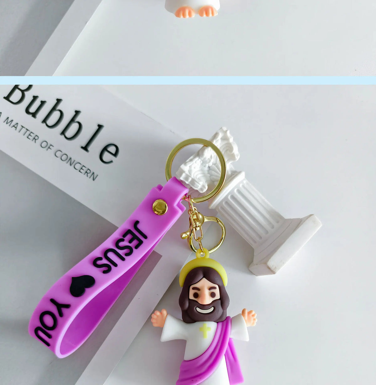 A silicone keychain featuring a Jesus figure and a pink strap, displayed next to the word Bubble.