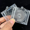 A hand holds a mini transparent CD keychain featuring a silver-colored disc and clear plastic casing.