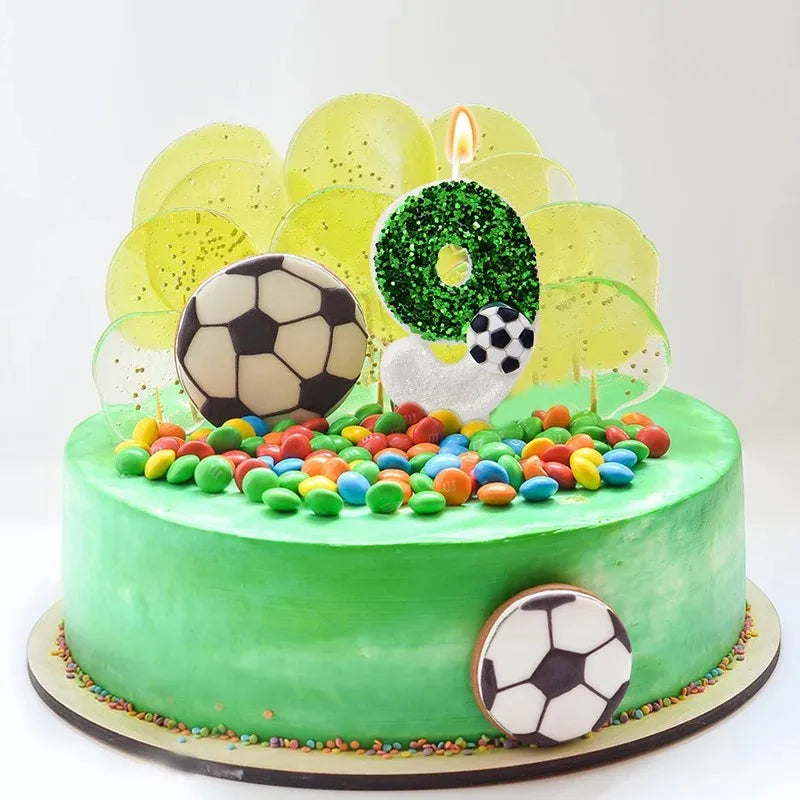 A green cake decorated with soccer balls and candles, featuring a large green number 8 topper.