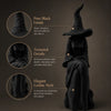 A black velvet witch figurine with a pointed hat and flowing robe, showcasing pure black finish and textured details.