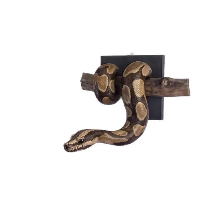 A sculpture of a ball python in golden resin mounted on a wooden piece.