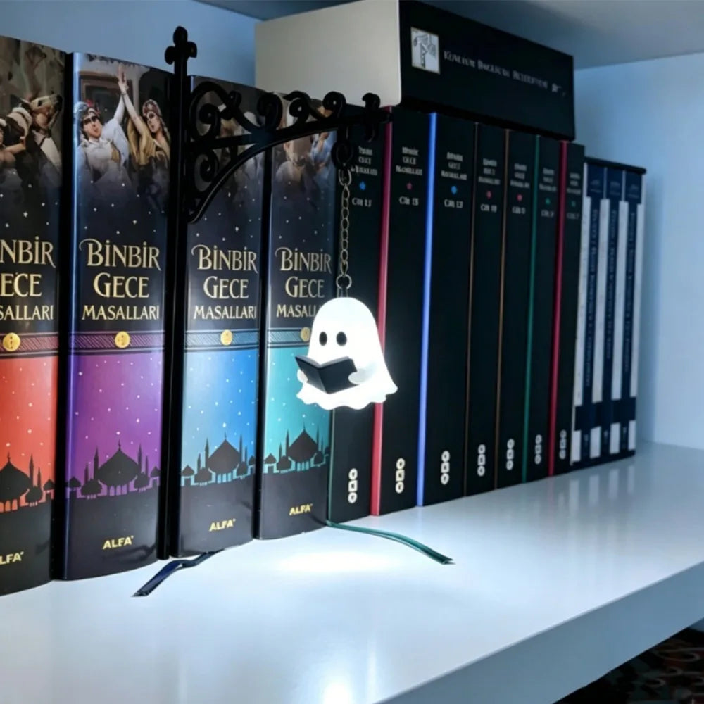 A row of vintage books with titles like Binbir Gece and Alfa displayed on a white shelf.
