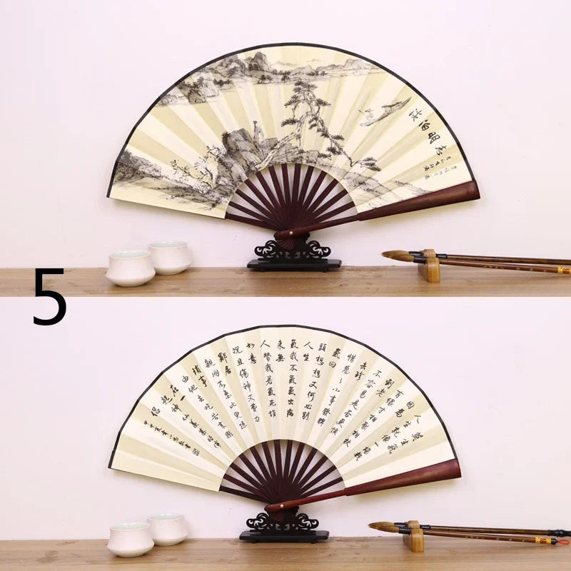 A large, round decorative fan with a black and cream pattern is displayed on a wooden shelf.