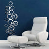A white modern armchair is placed against a dark blue wall, with silver acrylic mirror polka dot wall stickers displayed near