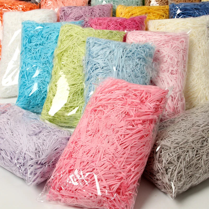 A collection of vibrant crinkle paper shreds in various colors including pink, green, blue, and white.