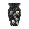 A black decorative vase shaped like a cluster of skulls made from resin.