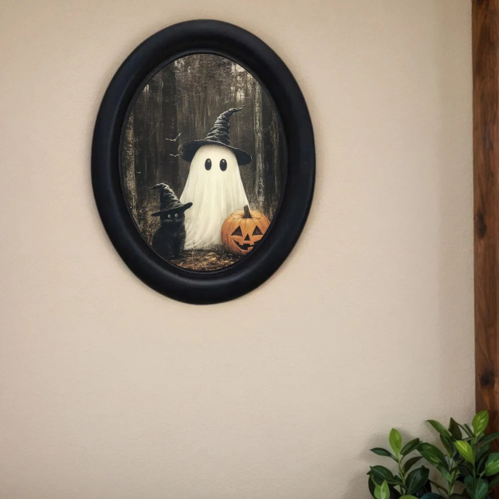 Vintage wall art featuring a ghost witch and a black cat in an oval frame.