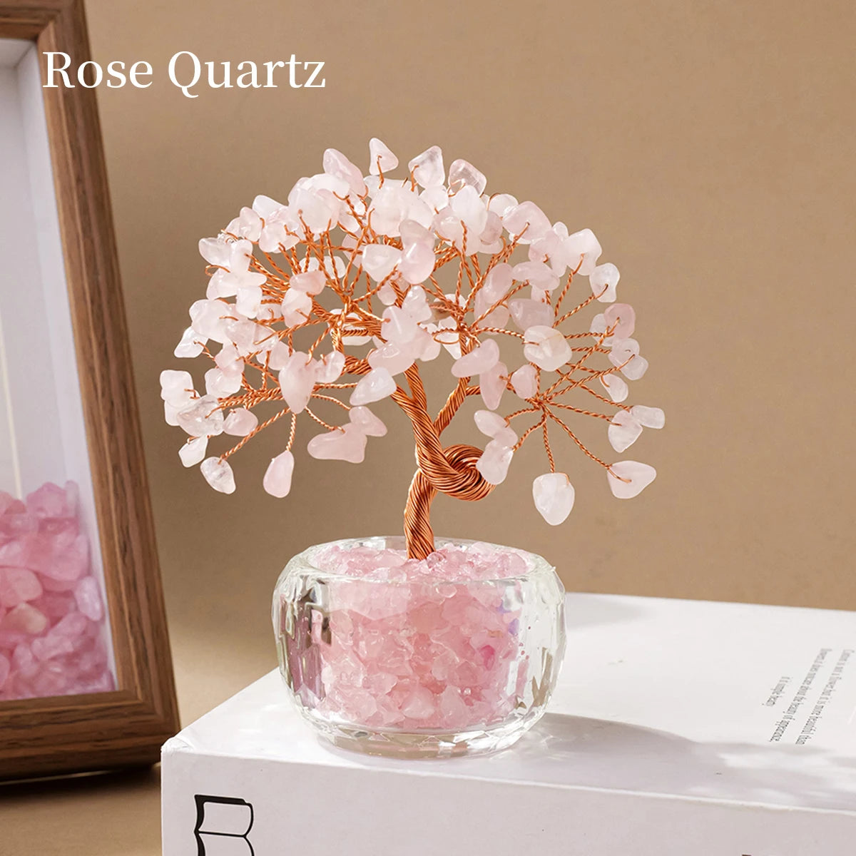 A delicate Rose Quartz money tree ornament featuring pink crystal blossoms on a wooden branch.