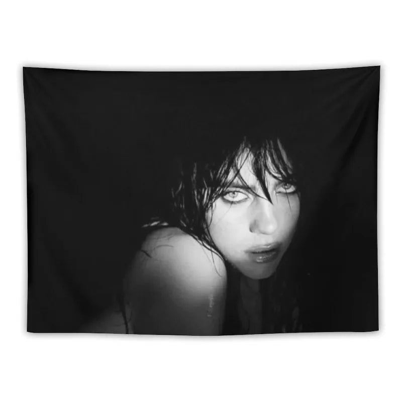 A black and white portrait of Billie Eilish with dark hair looking intensely at the camera.