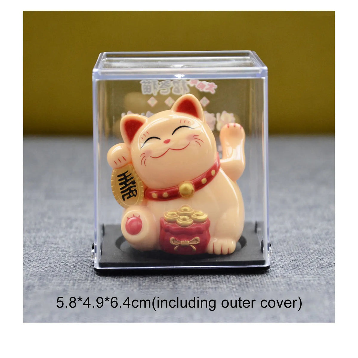 A small, light pink solar-powered figurine of a cat with a happy expression and a gold coin.