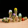 A collection of natural crystal tree of life chimes in various colors, including yellow, purple, and green, displayed on a wo