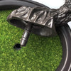 A dark bronze artificial bonsai tree with green foliage is shown emerging from a black pot.