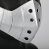 A silver cosplay mask with segmented design and small holes is shown on a dark surface.