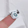 A white vintage rotary desk phone miniature decor is held by a finger against a white background.