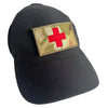 Black baseball cap with a gold camouflage patch featuring a red medical cross.