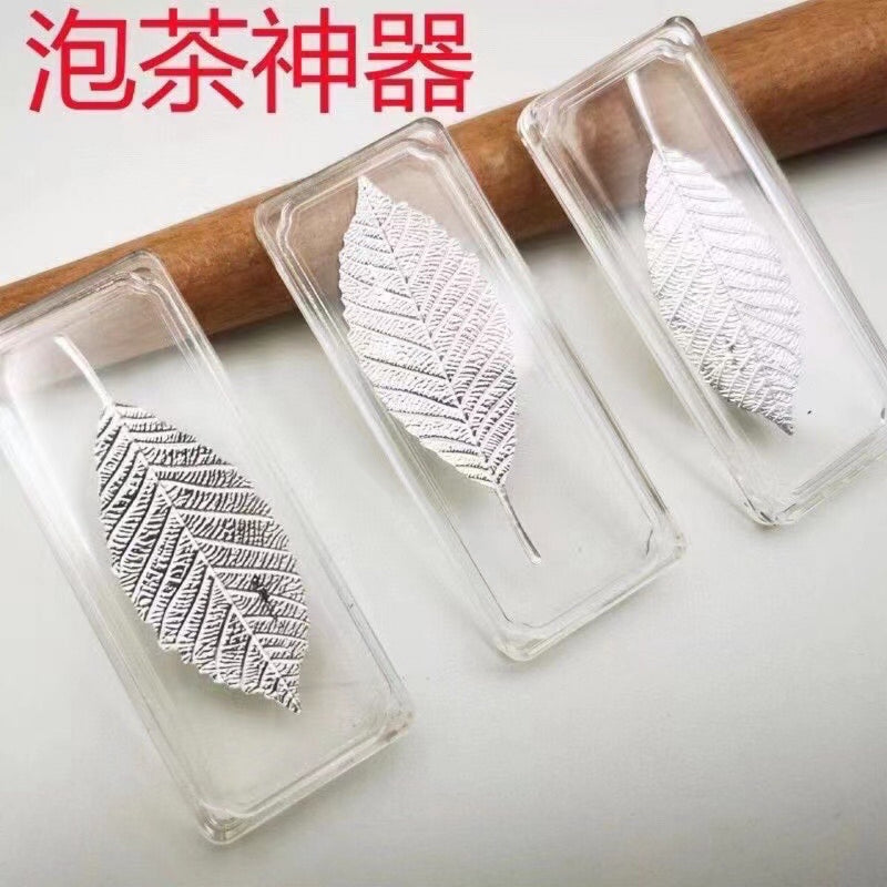 Clear glass tea brewing leaves in a wooden context
