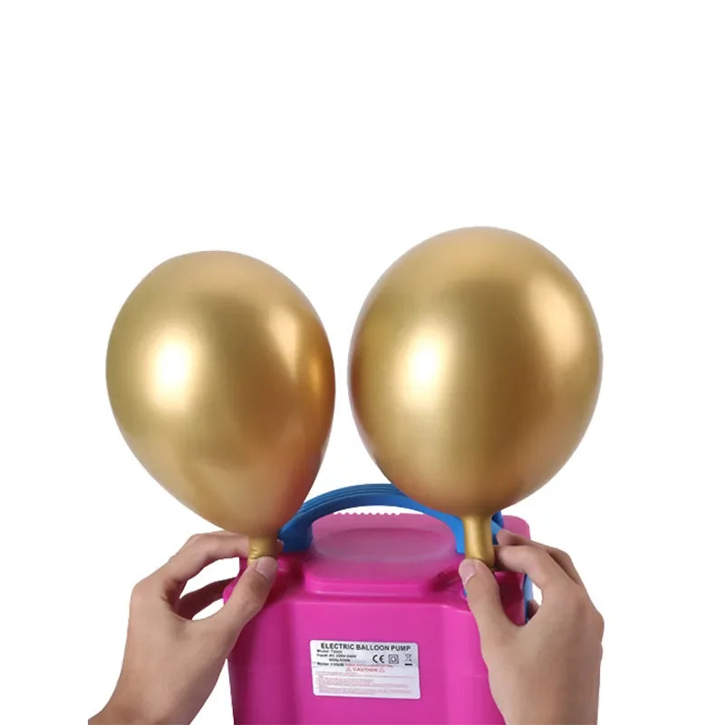 Hands are operating a pink electric balloon pump with gold balloons.