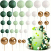 A collection of gold and silver foam ball cake toppers on sticks for party decorations.
