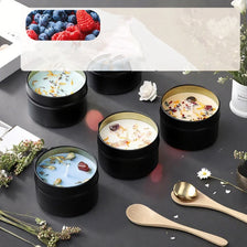 A collection of soy wax aromatherapy candles in metallic tins with dried flowers and fresh berries, set on a dark surface.