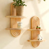 Geometric wooden wall shelves displaying a potted plant, a candle, and a small figurine.