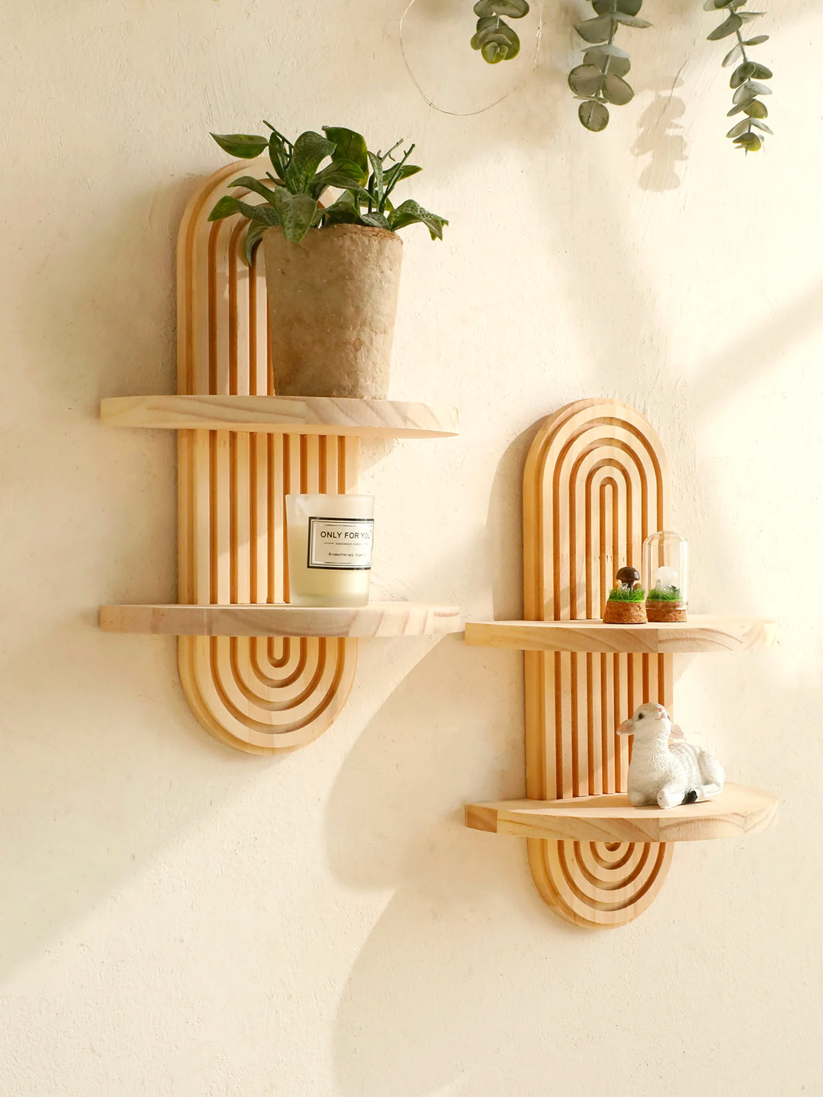 Geometric wooden wall shelves displaying a potted plant, a candle, and a small figurine.