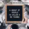 A wooden message board with the text A GROUP OF PEOPLE IS CALLED A NO THANKS displayed on a fuzzy white background.