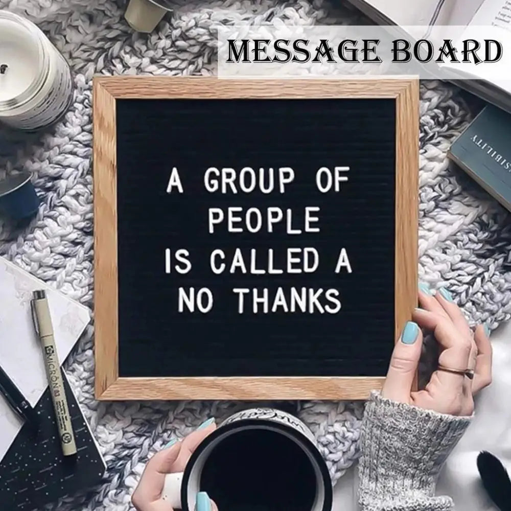 A wooden message board with the text A GROUP OF PEOPLE IS CALLED A NO THANKS displayed on a fuzzy white background.