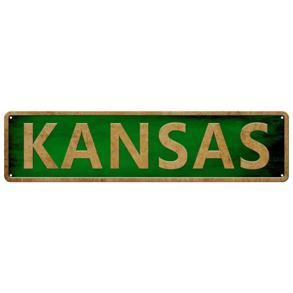 A rectangular wooden sign with green background and gold lettering spelling out KANSAS.