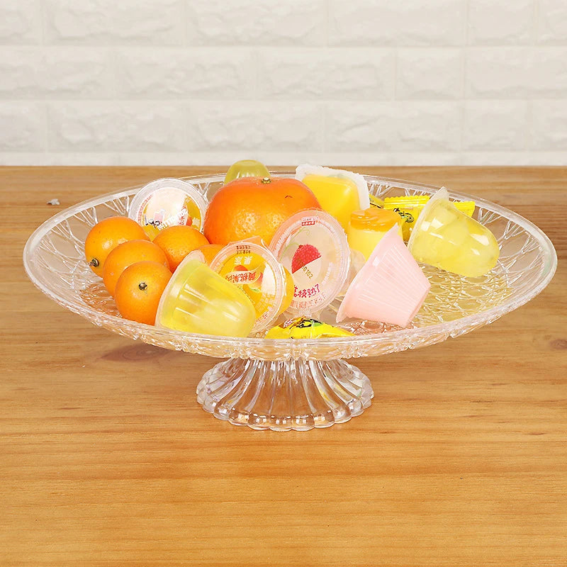 A clear acrylic serving dish filled with various colorful fruit pieces and desserts for entertaining.