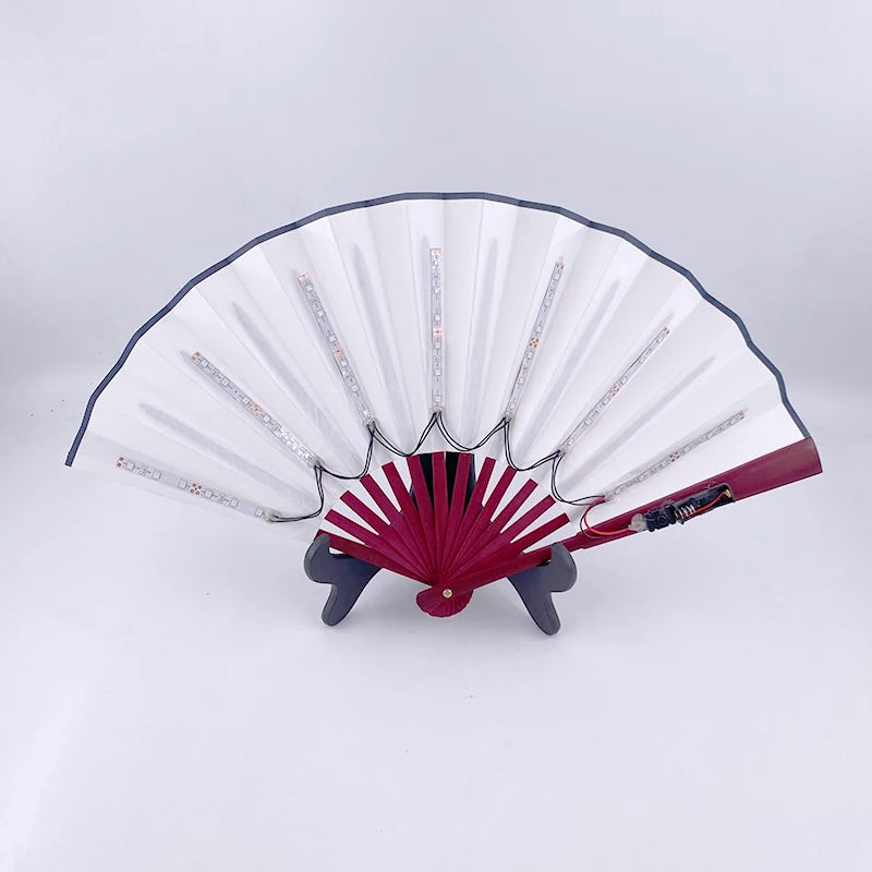 A white and red multi-mode LED party fan with pleated blades and a dark stand.