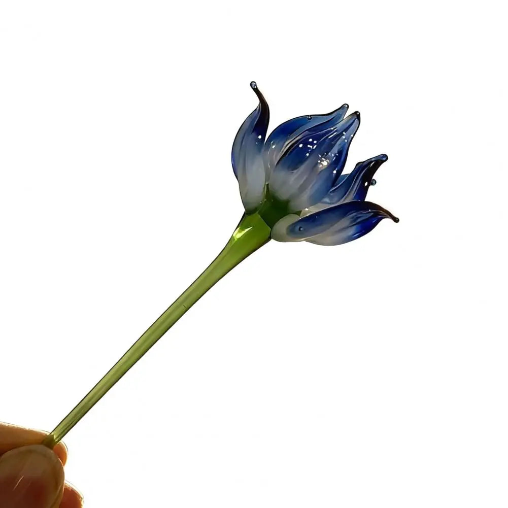 Handcrafted blue glass flower sculpture with a green stem and petals