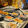 A close-up of an occult pentagram tablecloth with Hebrew runes and several tarot cards laid out on the surface.