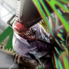 A close-up of a chainsaw blade and handle, featuring vibrant green and rainbow light effects on a canvas wall art poster.