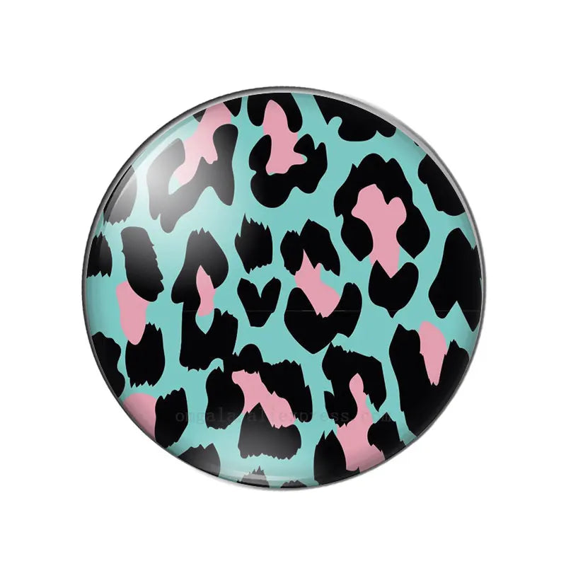 A round glass cabochon with a black and pink leopard print pattern.