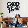 Un couple souriant posant avec une œuvre d'art murale indiquant 'God Bless Our Home'