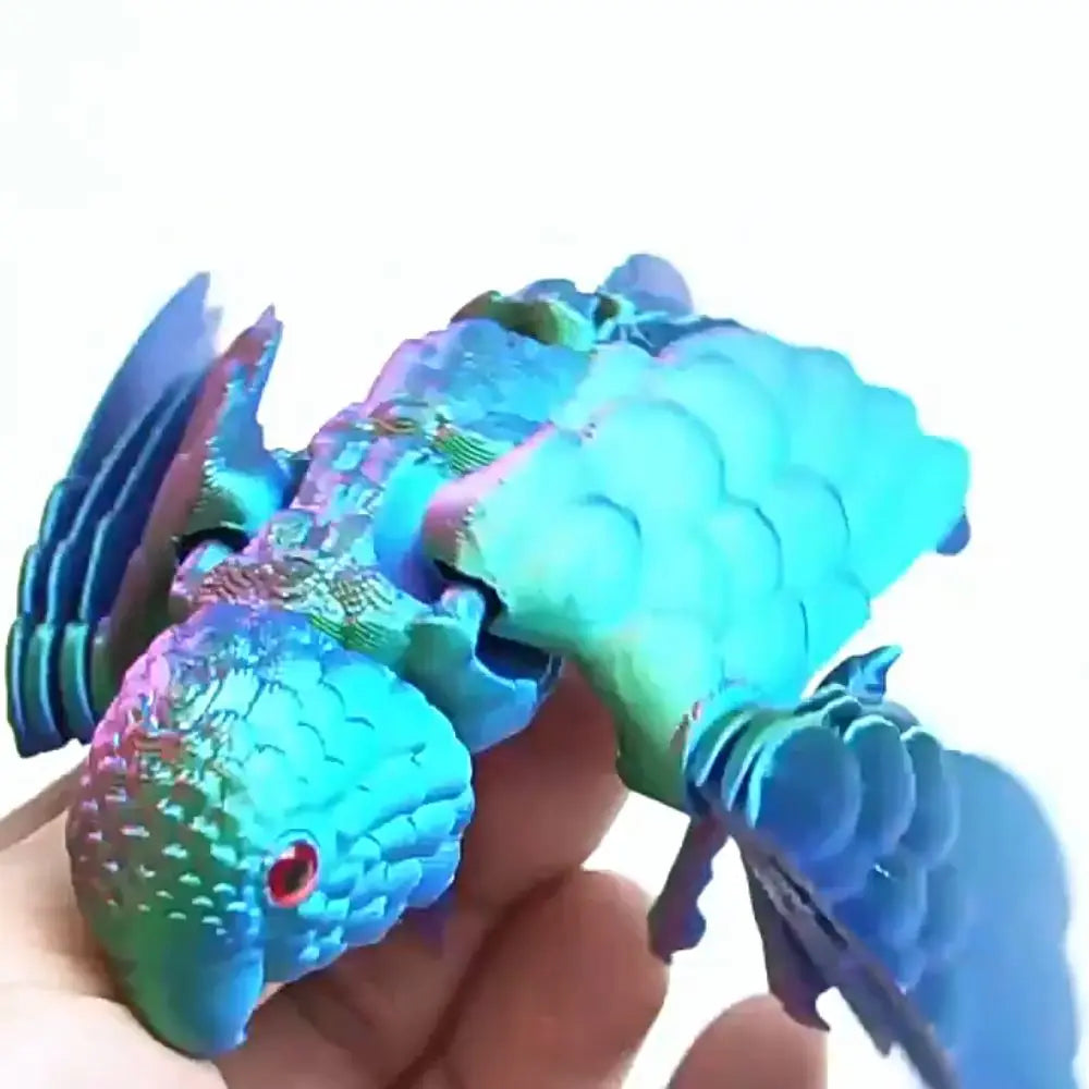 A hand holds a bright blue parrot figurine with movable wings.