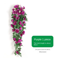 A vertical arrangement of purple silk roses and green foliage used as a hanging vine for home décor.