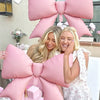 A set of pink balloon banners shaped like bows and flowers for a princess birthday theme.