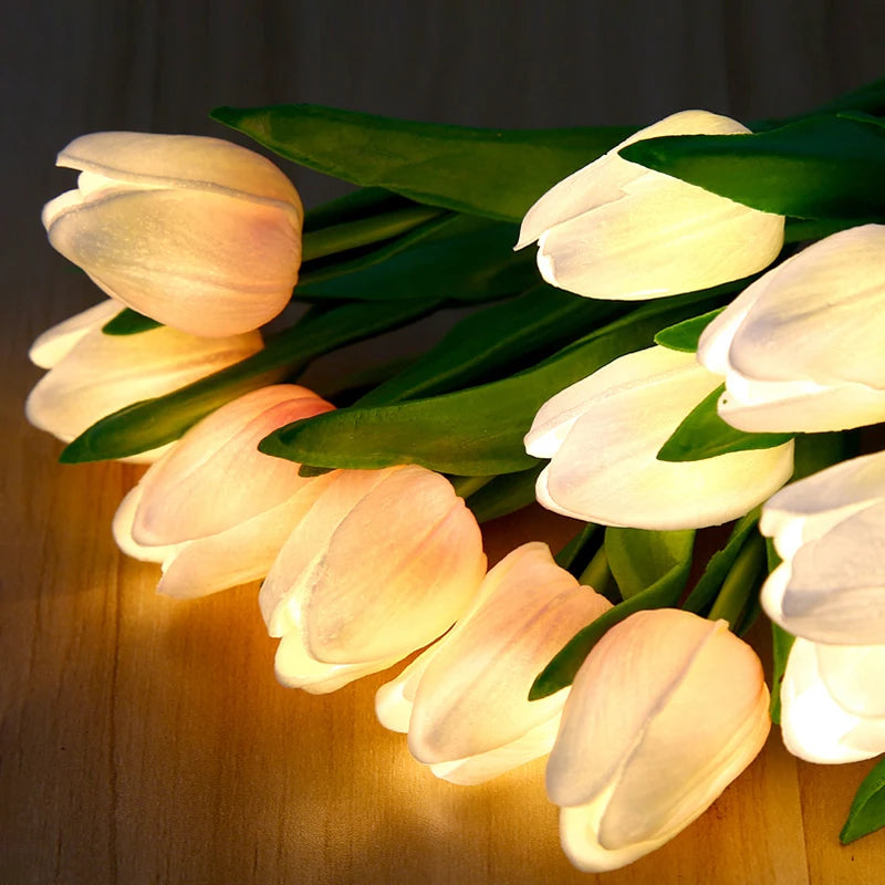 A cluster of white and yellow LED tulips glowing softly in a dark setting.