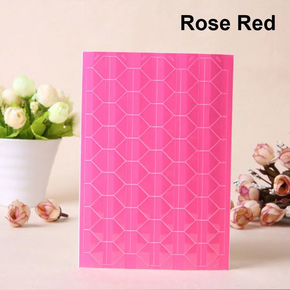 A pink PVC photo corner protector with a geometric pattern displayed next to white roses.